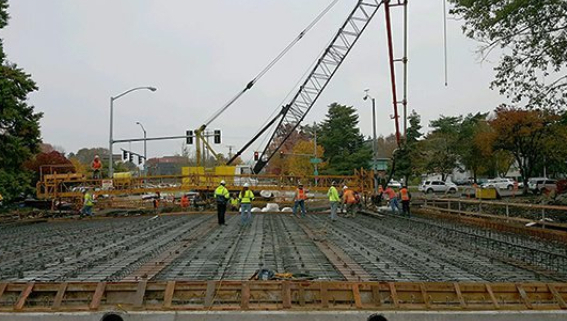 A group of people standing around on top of concrete.