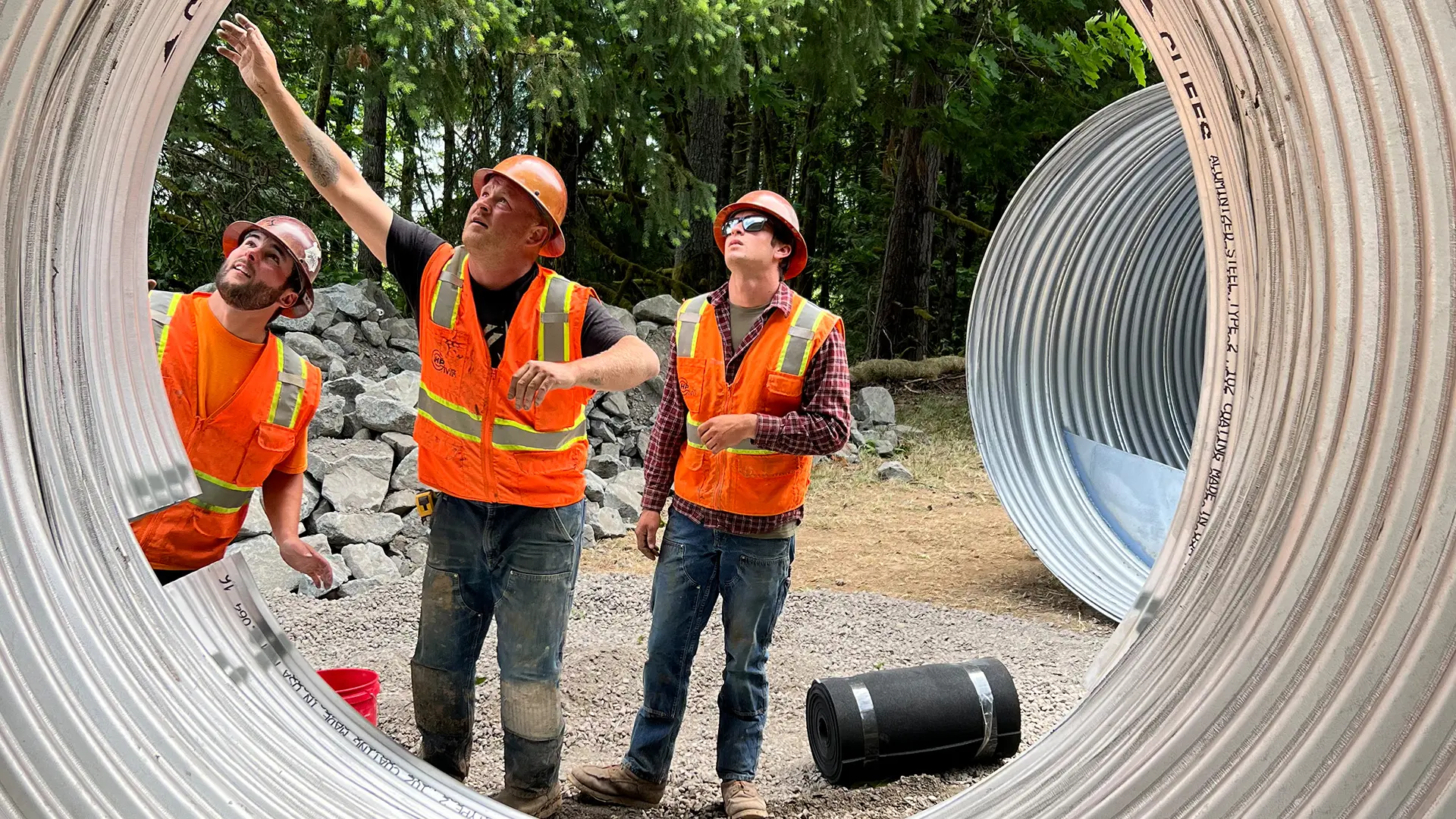 Three workers looking at the thickness of a pipeline