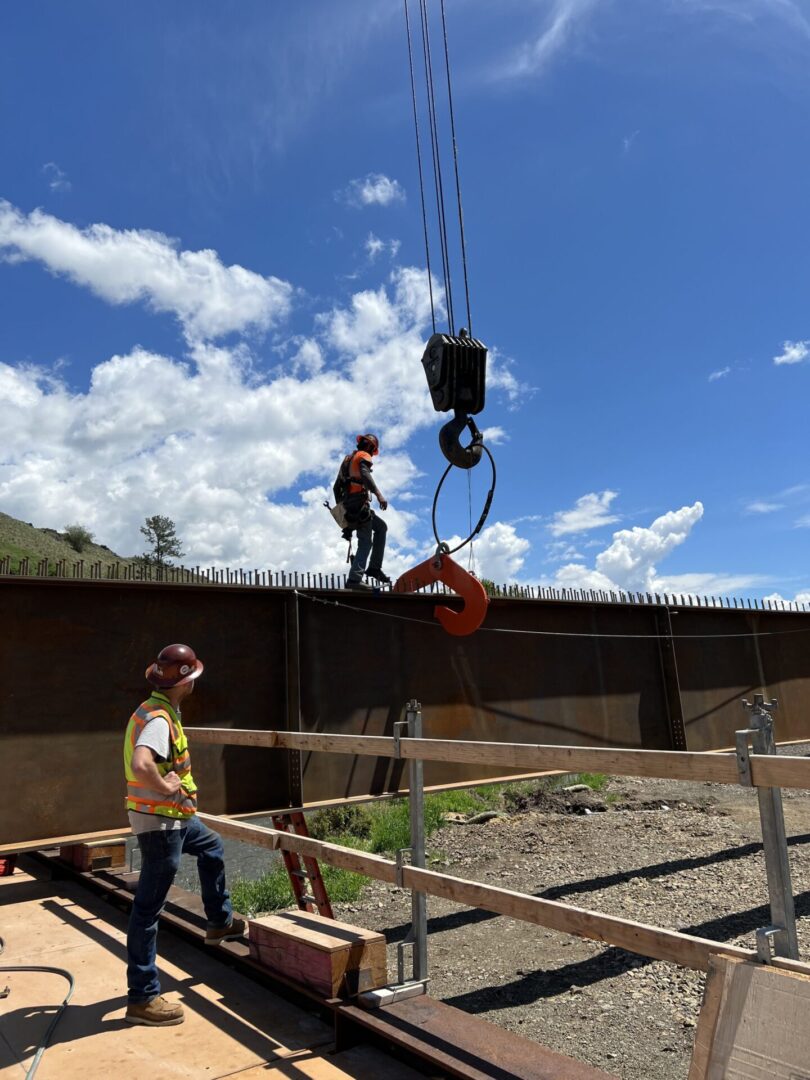 Two workers working at a site along with pillars